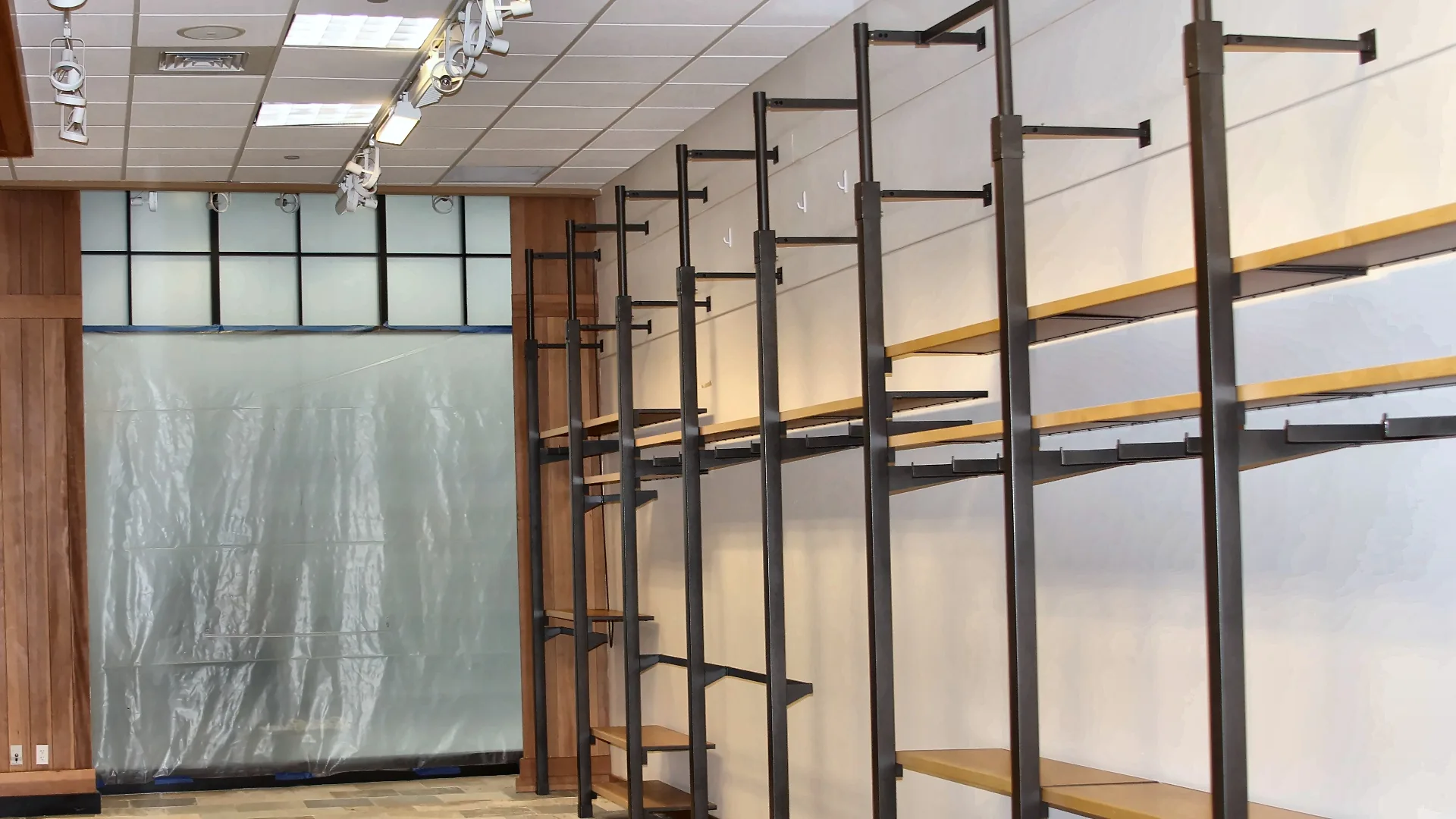 Retail tenant improvement build-out with new ceiling grid, track lighting and wall shelving system in a Northern California shopping center