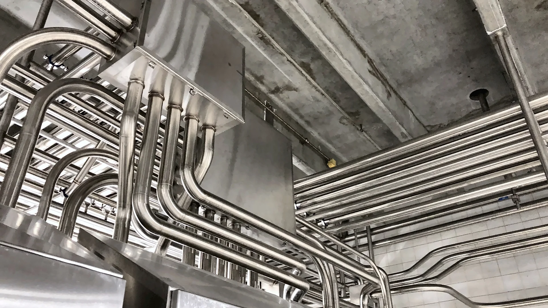 Stainless steel process piping runs inside a food processing plant in California